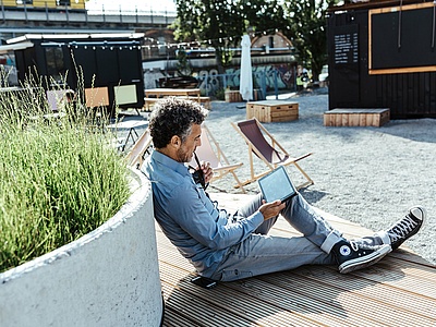 Mann auf Parkbank mit Tablet