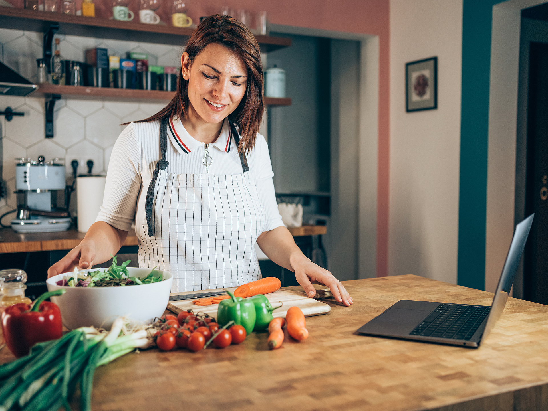 Frau vor dem Laptop mit gesunden Lebensmitteln