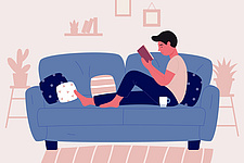 Ein Mann liest auf dem Sofa