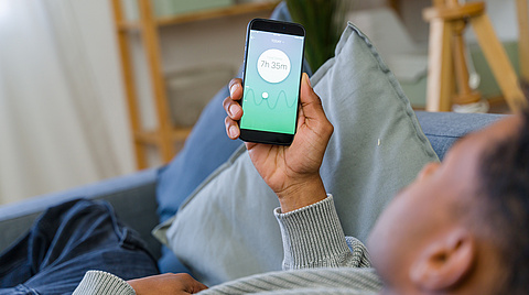 Mann schaut auf Smartphone App